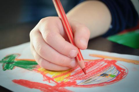 immagine che presenta la mano di un bambino che disegna