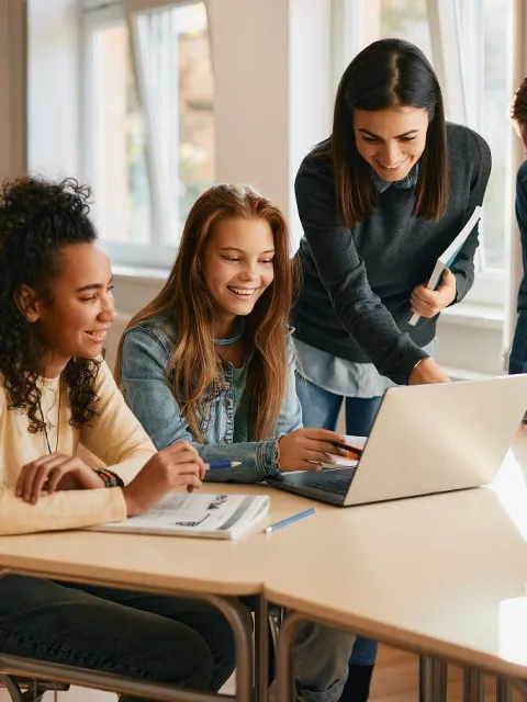 gruppo di giovani seduti a una scrivania che consultano un pc