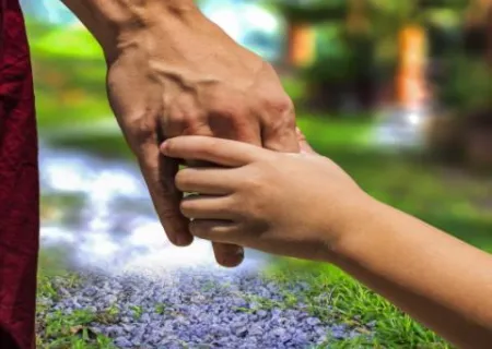 mano di adulto che tiene mano di minorenne