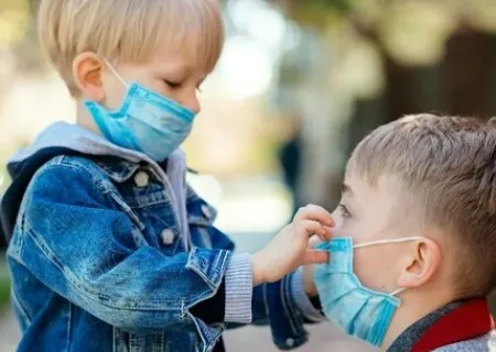 immagine con due bambini che indossano la mascherina chirurgica