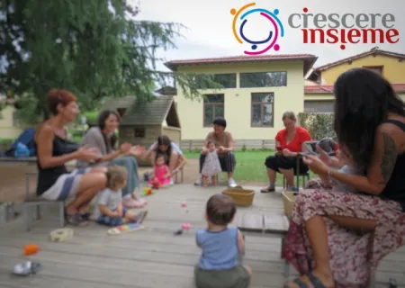 Un gruppo di genitori e bambini ritratti durante un incontro del progetto Crescere insieme