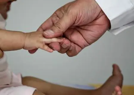 immagine con la mano di un medico che tiene quella di un bambino 