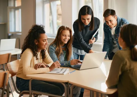 gruppo di giovani seduti a una scrivania che consultano un pc